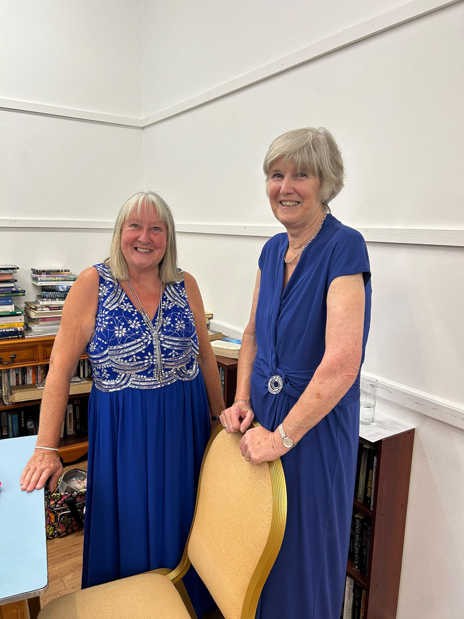 Two choir members in blue evening wear, ready to perform.